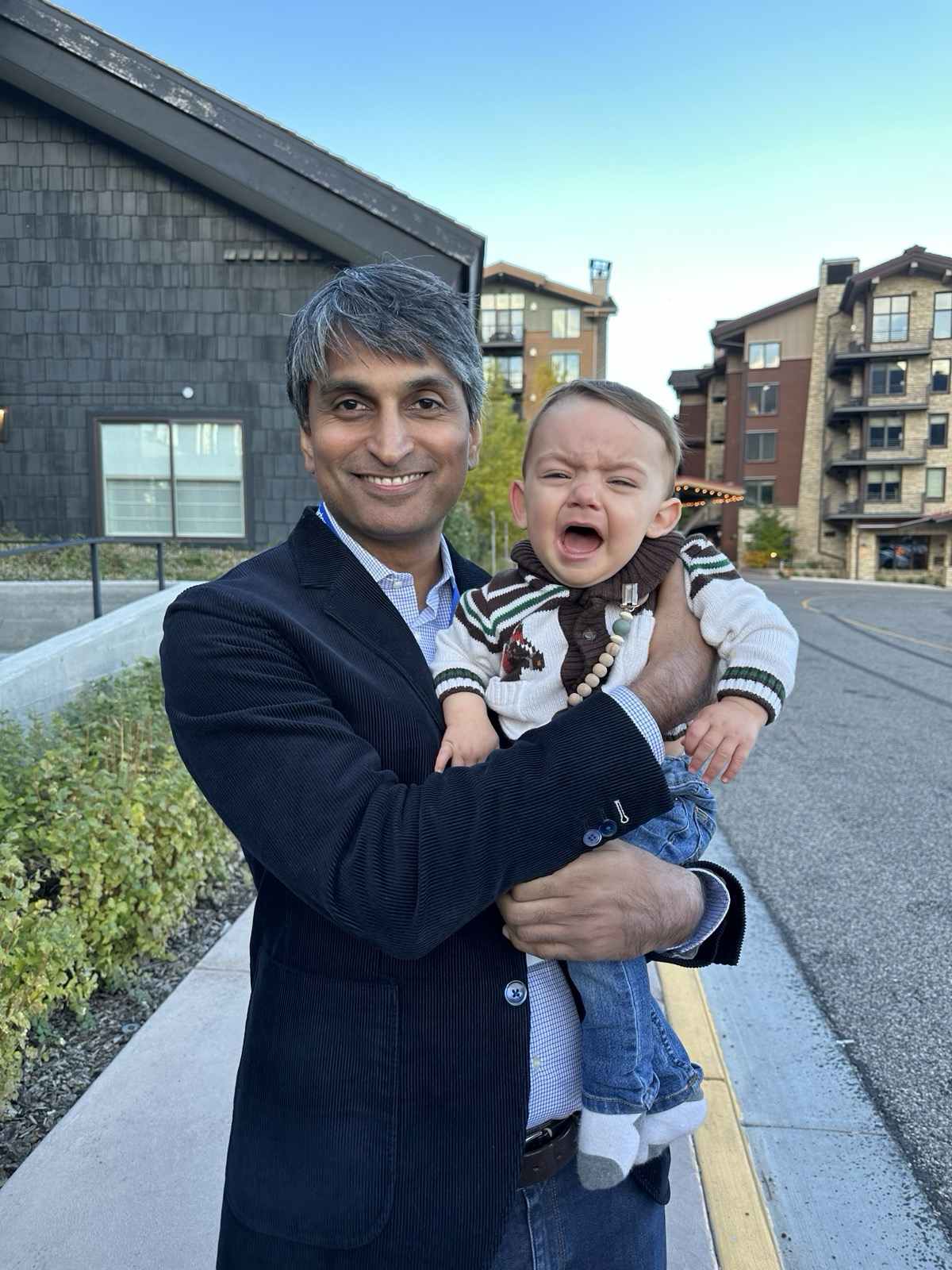 Raza Khan holding Rachael's crying son outdoors